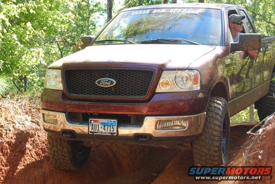 Red 2005 Ford F-150 off-roading on a dirt trail