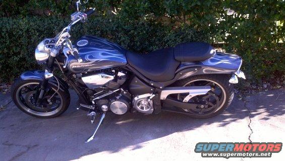 Blue motorcycle with flame decals parked on pavement
