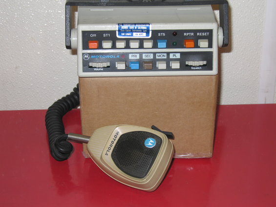 Motorola radio unit with microphone. Unit has buttons labeled OFF, ST1, ST5, RPTR, RESET, PRI, SEC, MON, PL, VOLUME, and SQUELCH