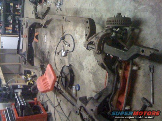 Vehicle frame and suspension components laid out on a garage floor