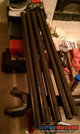 metal pipes, a differential, and other vehicle parts on the floor