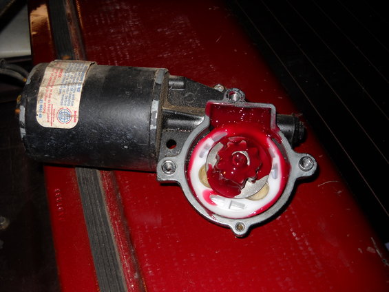 Windshield wiper motor with red grease inside the gear housing