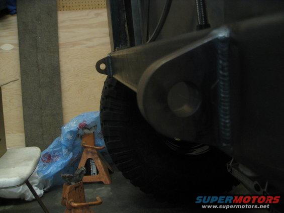 Jeep YJ frame with welded bracket and tire on jack stands