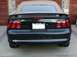 1992 Mercury Grand Marquis - The rear of a black Ford Mustang SVT Cobra convertible is shown, its distinctive taillights and 'COBRA' badging.
