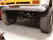 1971 International School Bus - The rear underside of a yellow school bus chassis is visible, showing its suspension and large tires.