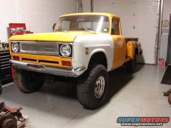 Yellow and white pickup truck with a chrome grille and large tires