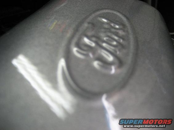 Embossed Ford emblem on a gray, metallic surface