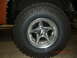 1973 Ford Bronco - Close-up view of a chrome wheel and tire on an off-road vehicle.