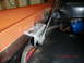 1973 Ford Bronco - Close-up view of a vehicle's hood hinge bracket and associated wiring.