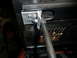 1973 Ford Bronco - Custom hood latch mechanism modification a gas strut mount and visible date stamp.