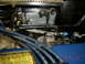 1973 Ford Bronco - A detailed view of engine parts, including a carburetor and spark plug wires, with an emissions control information sticker visible.