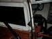 1973 Ford Bronco - The interior of a vehicle shows a mounted chainsaw and a black window.