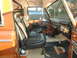 1973 Ford Bronco - The interior of a 1973 Ford Bronco features black seats, a dashboard with various controls, and branded floor mats.