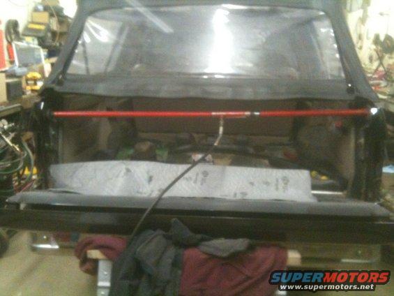 1993 Ford Bronco rear interior with soft top removed, showing a red roll bar and cargo area