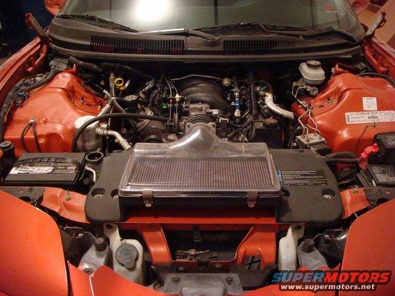 Red 2001 Pontiac Trans Am engine bay with exposed V8 engine, air intake, and battery