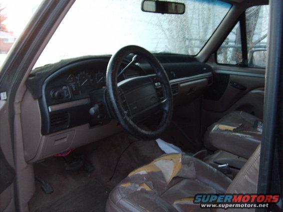 Interior of a 1995 Ford Bronco showing dashboard, steering wheel, and worn seats