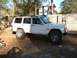 1994 Ford Explorer - A white Jeep Cherokee is parked outdoors, showing its side profile with off-road tires and aftermarket wheels.