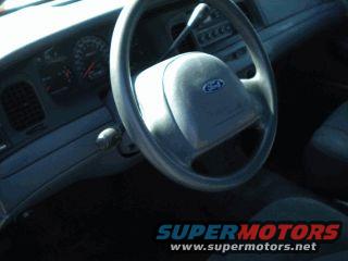 Interior of a 2002 Ford Crown Victoria, showing the steering wheel, dashboard, and part of the driver's seat