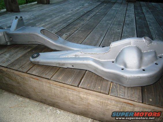 front axle housing and control arm on wooden deck