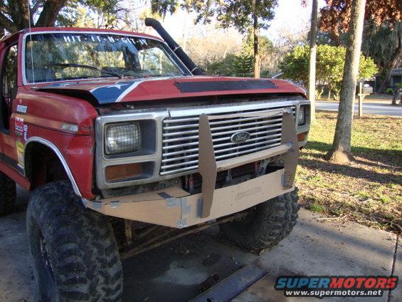 Red Ford Bronco with custom front bumper and snorkel intake. Hood has a Confederate flag decal