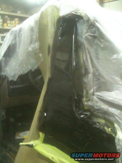 vehicle interior covered in plastic sheeting with some parts painted black