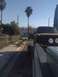 1992 Ford Ranger - A dark-colored truck is being towed by another truck, viewed from the side and slightly from the front.