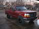 1996 Ford F-150 - This red Ford F-150 pickup truck is parked in a driveway with houses in the background.