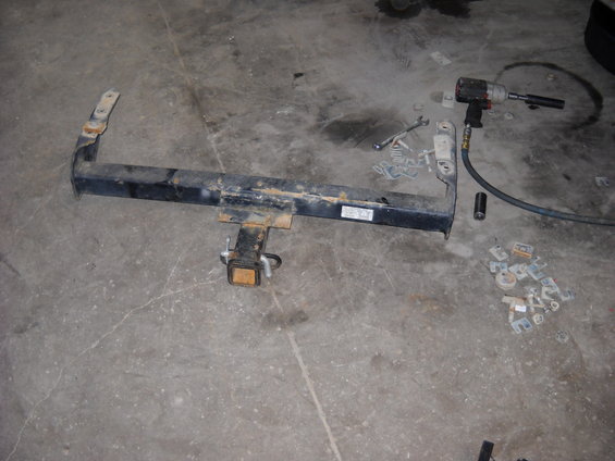Trailer hitch with mounting hardware and impact wrench on concrete floor