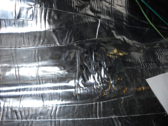 Shiny, crinkled insulation material covers the interior walls and ceiling