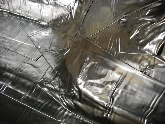 Silver metallic material with visible seams and wrinkles