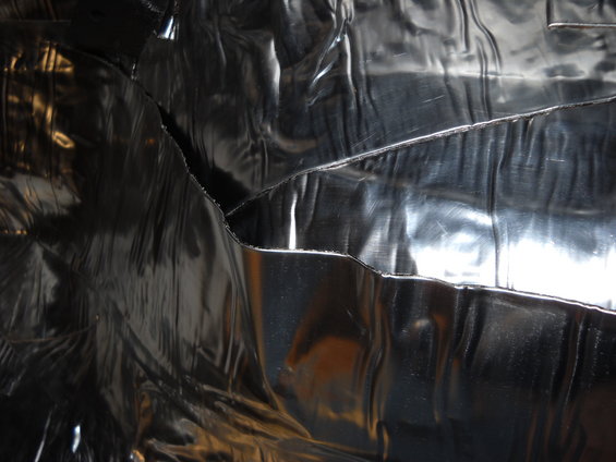 Crinkled metallic material, possibly insulation or a reflective surface