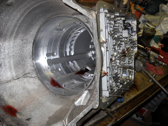 Transmission valve body with red fluid visible inside housing