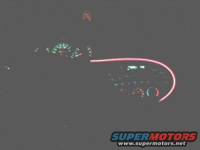 1997 Ford Taurus dashboard at night with illuminated gauges and radio display