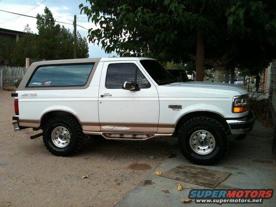 White 1996 Ford Bronco side profile with tan top and brown trim