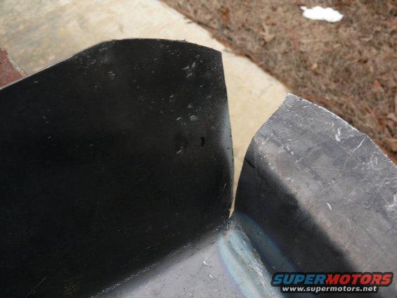 Two curved metal parts, one black and one gray, with visible seams and edges