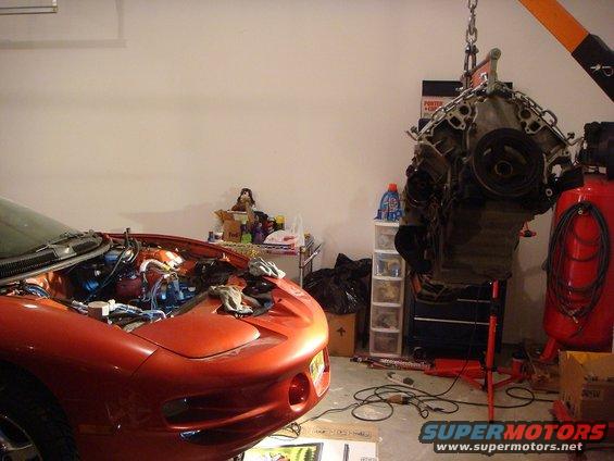 2001 Pontiac Trans Am with hood open, engine being lifted out by a hoist