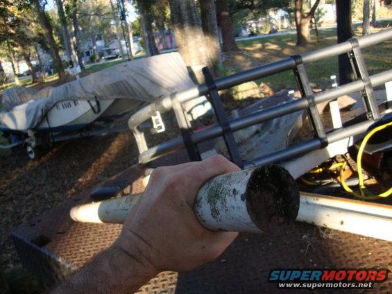 Boat on trailer with a hand holding a pipe