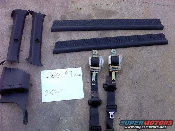 Interior car parts: seatbelts, trim pieces, and a small panel