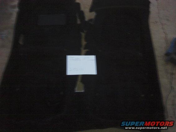Black car floor mats with a white paper note on them