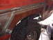 1979 Ford Bronco - Welding is being done on the rear fender of a vehicle, with a large tire visible.
