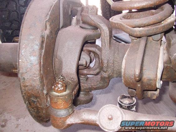 Close-up of rusty front suspension parts and tire tread