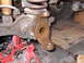 1979 Ford Bronco - Close-up of a rusty vehicle suspension component supported by red jack stands.