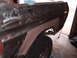 1979 Ford Bronco - The rear fender of a 1979 Ford Bronco shows extensive bodywork in progress, with primer and exposed metal visible.