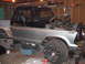 1979 Ford Bronco - This Ford truck, likely from the mid-1970s, is undergoing extensive bodywork and mechanical repairs in a garage setting.