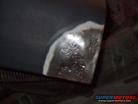 close-up of a rusty metal panel with primer and some pitting