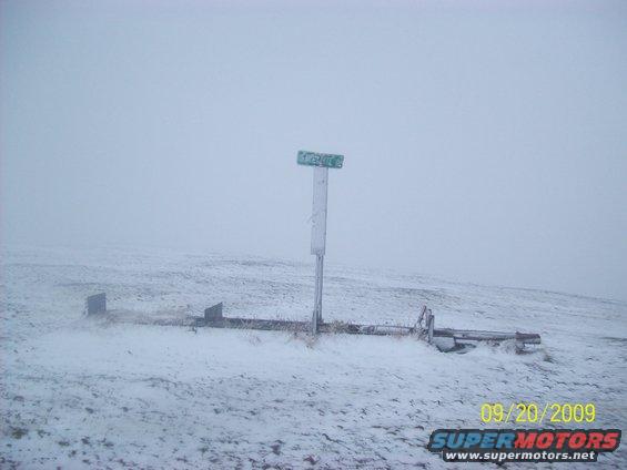 snowy field with a signpost and some metal structures, date stamp 09/20/2009