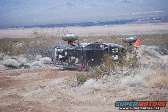 Off-road buggy flipped on its side in desert terrain