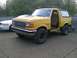 1988 Ford Bronco - This 1988 Ford Bronco is yellow and parked outside with its driver's door ajar.