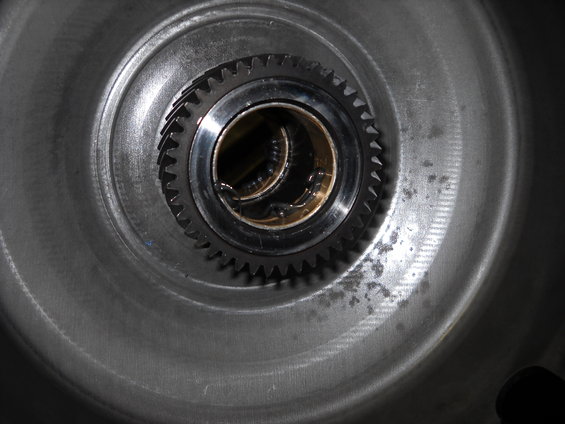 Close-up of a transmission gear with internal splines and a bronze bushing