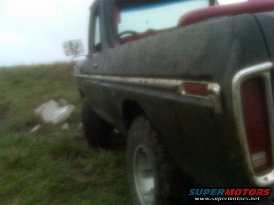 Side view of a 1978 Ford Bronco parked on a grassy hill